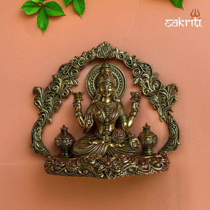 Sacred Needs Brass WC Lakshmi Wall Mount with Frame – 3.7 Inch (9.4 cm) Height | Lakshmi Idol Wall Hanging for Pooja Room & Home Décor