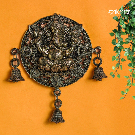 Sacred Needs Brass WC Ganesha Round Wall Mount with Bell – 7.2 Inch (18.3 cm) Height | Decorative Brass Ganesha Wall Hanging for Pooja Room & Entrance